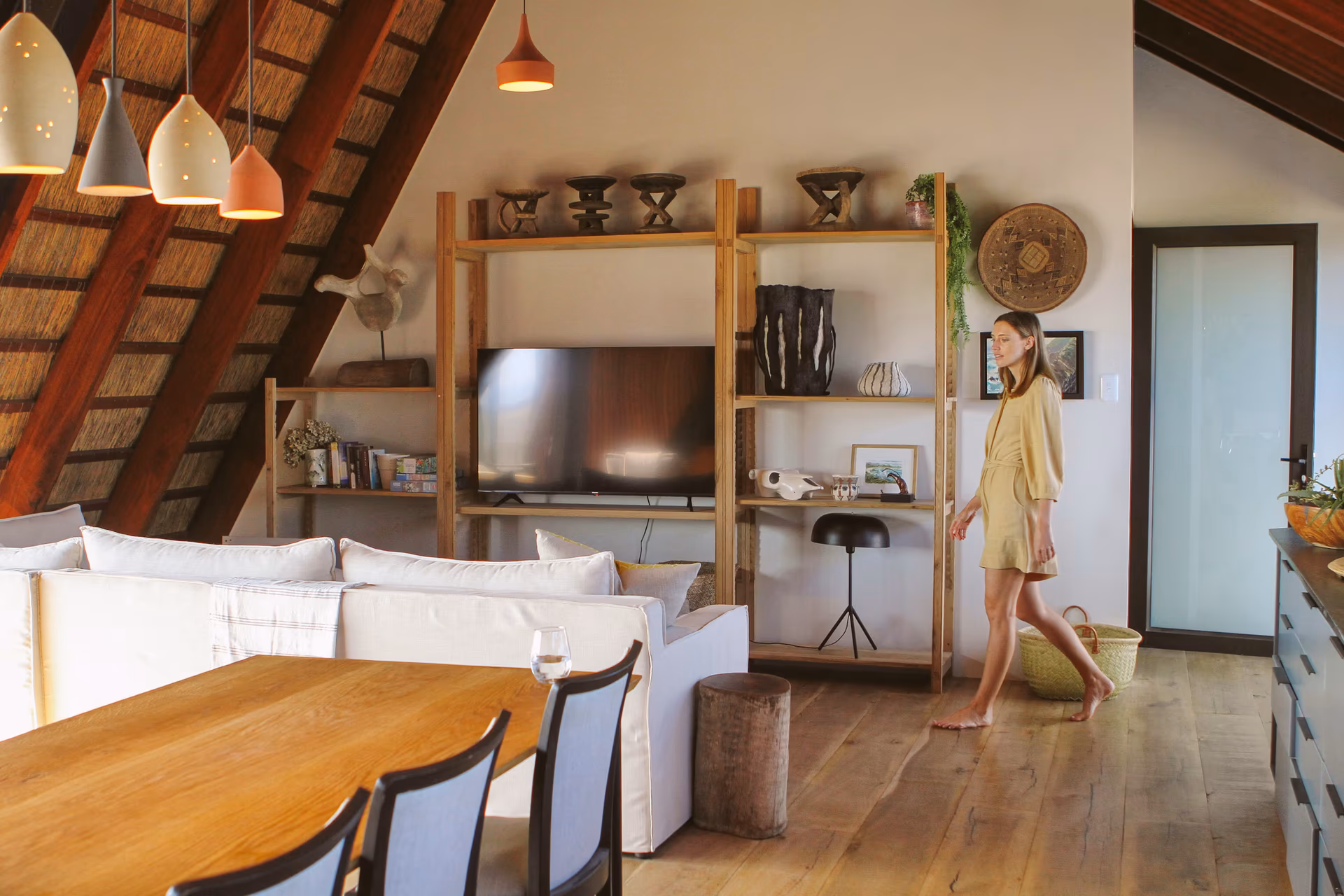 The dining and television area beneath the exposed thatch roof