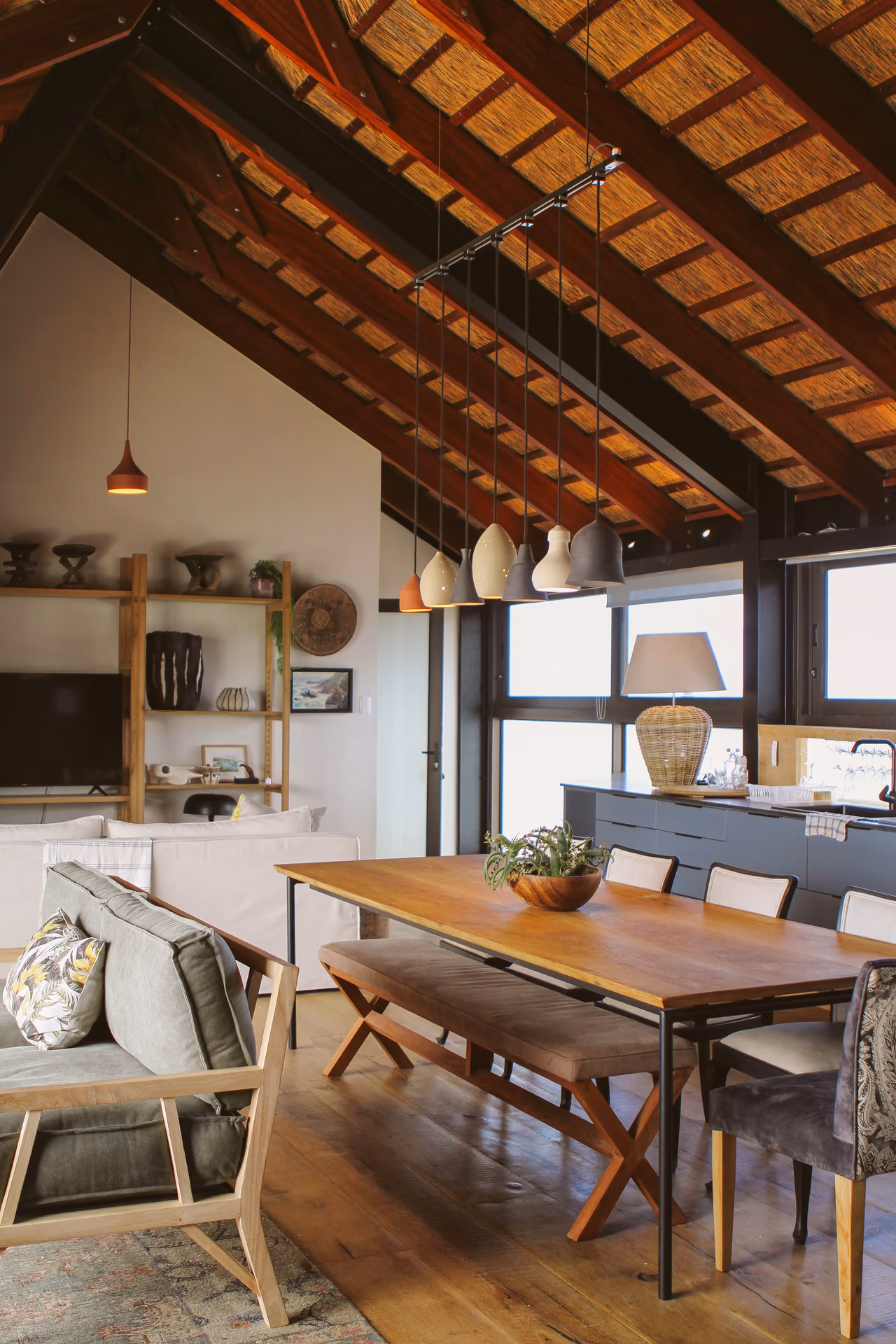 Casa Caro's open-plan dining room and living space beneath the thatch roof